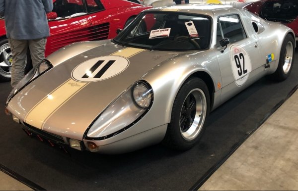 Състезателната писта Solitude близо до Щутгарт, 26 ноември 1963 година. Porsche представя Carrera GTS 0 с фабричен код 904. Това е  първият сериен автомобил с пластмасова каросерия. Инженерите и търговците в Porsche взимат строго рационално решение: каросерия, тежаща малко под 100 кг, изработена от подсилена със стъклени влакна полиестерна смола Palatal на BASF. Тя е залепена върху 45-килограмовата стоманена кутия от Ernst Heinkel Flugzeugbau. 

Тази комбинация е лека, достатъчно твърда и евтина за производство. За GT motorsport - Porsche прави около 120 бройки Carrera GTS, фабричен код 904. Колата има може би най-дългите фарове преди Peugeot 208. И да, красотата също е част от концепцията.  

Porsche KG трябва да продаде най-малко 100 бройки, за да бъде одобрена за състезателната серия GT. Така Фердинанд Александър Порше, известен като Буци, поема дизайна. Пластмасовото Porsche принуждава шофьора да заеме една и съща  поза. Подплатените седалки, изработени от пластмаса, подсилена със стъклени влакна, са здраво закрепени към тялото.

Пред задната ос на 650-килограмовия автомобил се намират, в зависимост от модела, четирицилиндров боксерен двигател със 155 или 180 к.с., шестцилиндров с 210 к.с. или осемцилиндров боксер с до 270 к.с.
